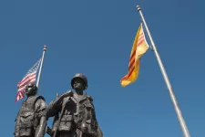 En staty av två soldater står vid amerikanska och sydvietnamesiska flaggor.