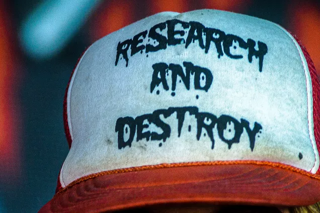 a baseball cap with the text "research and destroy"