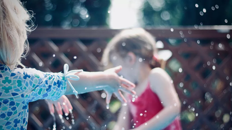 Children splashing water at each other. Photo: Jelleke Vanooteghem, Unsplash.