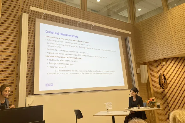 Professor Janine Leschke presents Anna Kallos' thesis in the auditorium.. 