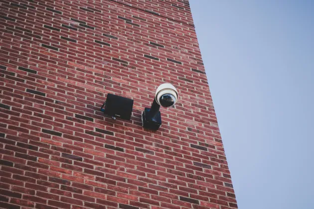 A CCTV camera on a brick wall.
