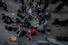 People gather to get soup from a street kitchen