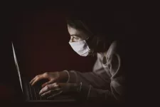 Woman in face mask using laptop computer. Photo: Engin Akyurt, unsplash