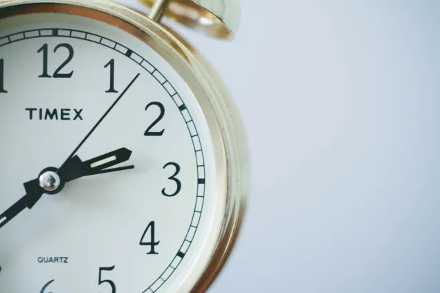 Analog väckarklocka i guld. Foto: Unsplash, Sonja Langford.