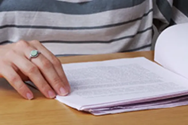 Händer som bläddrar i en uppsats.