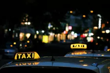 Bilar med lysande taxiskyltar i mörker.