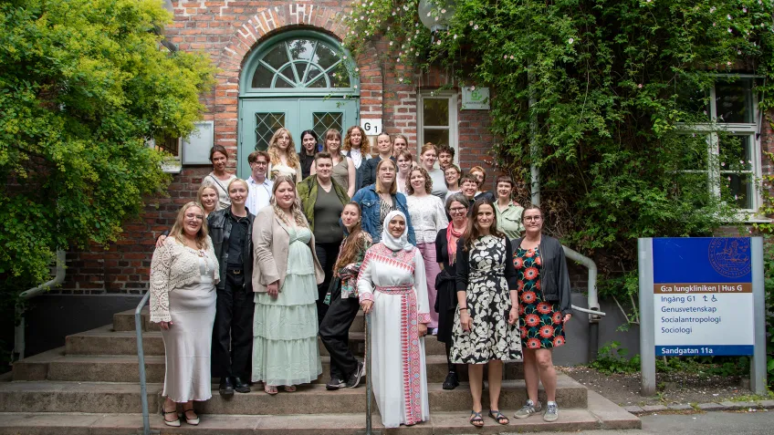 Gruppbild på trappa med finklädda studenter.
